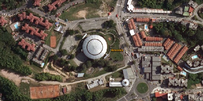 Un edificio en forma de platillo rodeado de apartamentos