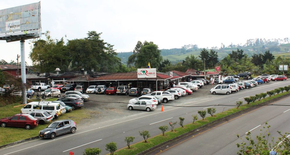 Automóviles parqueados al lado de una carretera de doble carril.