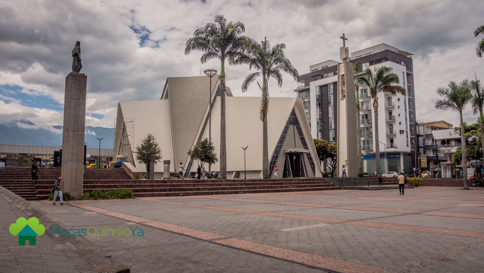 Foto que muestra una catedral con una estatua a un lado y al otro lado una cruz